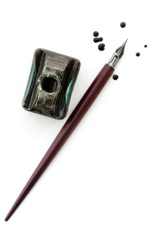 Vintage nib pen and inkwell, isolated on white with ink dropsの写真素材