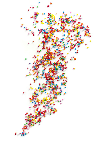 Colorful cake sprinkles scattered over white background.  Hundreds and Thousands.の写真素材