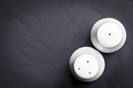 Salt and pepper shakers on dark slate.  Top view.の写真素材