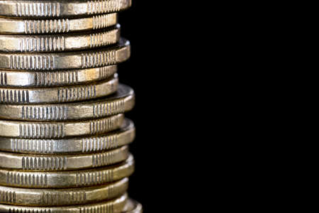 Stack of coins over black.  Finance background with copy space.