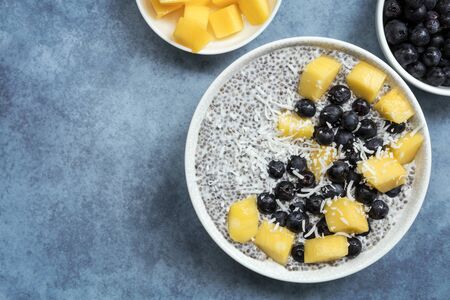 Chia seed pudding, top view, with blueberries, mango and coconut. Vegan superfood with almond milk.の写真素材