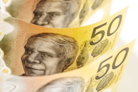 Australian money background.  Fifty dollar notes in soft focus over white.