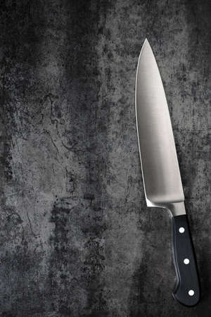 Chef knife on slate, top view.  High quality steel kitchenware.