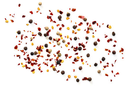 Black peppercorns and red hot chill flakes scattered over white.  Top view.