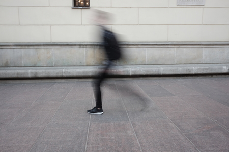 blurry person walks in townの写真素材