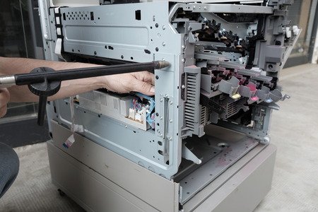 technician repairs photocopier