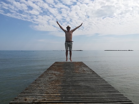 man is jumping on the catwalk on the sea