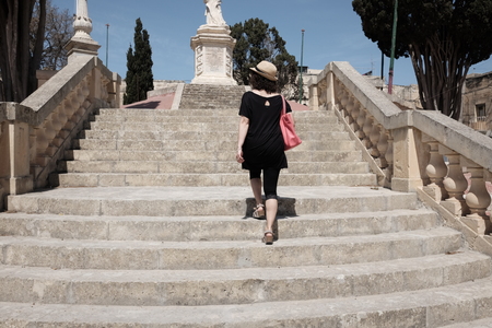 woman climbs stairs to mdina