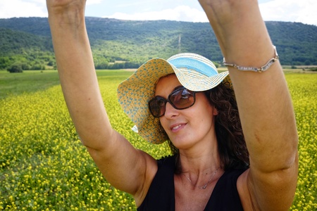 woman with hat in flowery fieldの写真素材