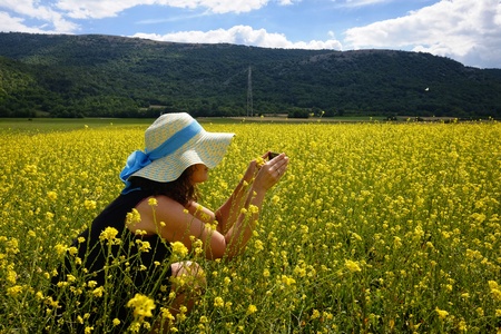 woman with hat in flowery fieldの写真素材