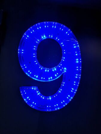 number nine illuminated on the wallの写真素材