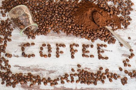 Spilled coffee beans and ground on the coffee table and writeの写真素材