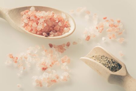 Himalayan salt and pepper on the spoon and light tableの写真素材
