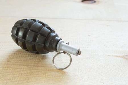 Hand grenade on a wooden boardの写真素材
