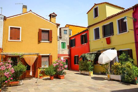 Small, cozy courtyard with colorful cottage /  Burano, Venice/ The small yard with bright walls of...