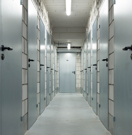 a long corridor in the basement with metal doorsの写真素材