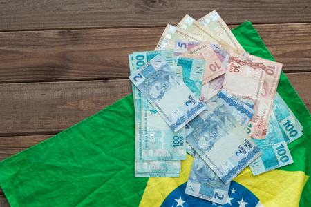 Brazilian money / reais and flag on the wooden table.の写真素材