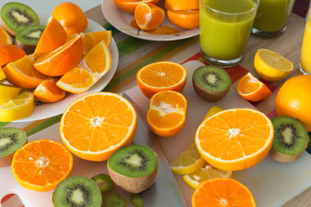 kitchen table set with various types of fruit and juices.の写真素材