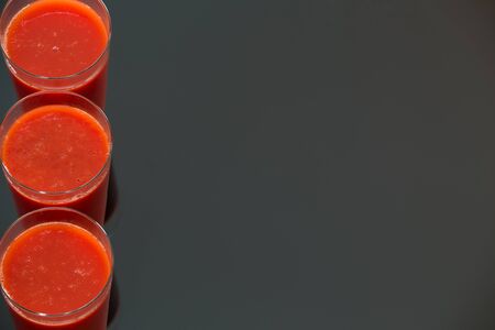 tomato juice isolated on black glass background. / place for textの写真素材