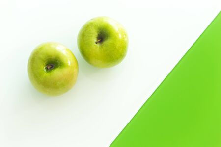 Green apples on the white-green glass backgroundの写真素材