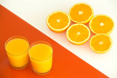 Orange juice and fruits on the white-orange glass background.の写真素材