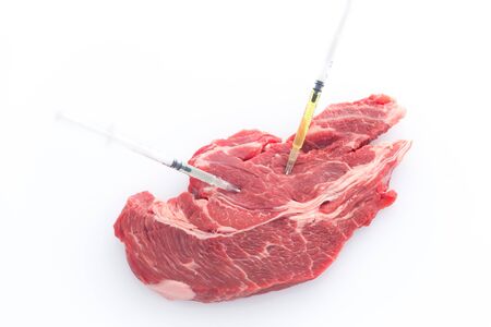 Modified food. Beef meat with embedded syringes / conceptの写真素材