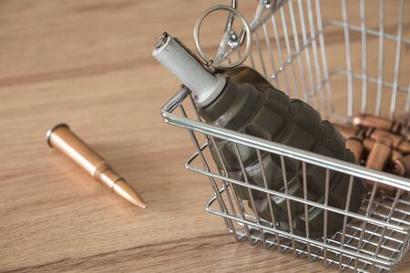 Arms trade, Shopping basket with grenade, conceptの写真素材