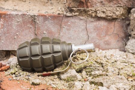 Hand grenade lying on a brick wallの写真素材