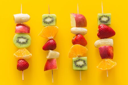 fruit skewers the concept of healthy eating / yellow glass background