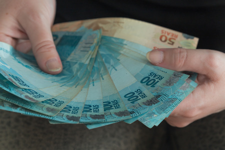 Big amount of brazilian money,  reais, in hand, concept of successの写真素材