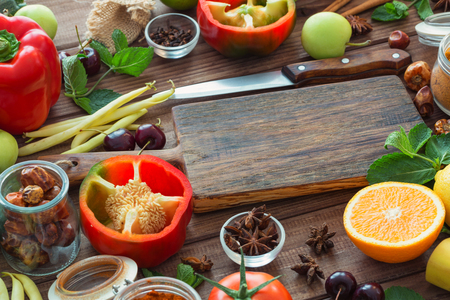 Healthy food, clean food selection:  fruits, vegetables, seeds, spices on brown boards with free space in the middleの写真素材
