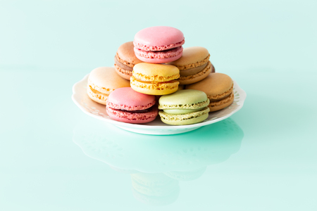 macaroons cake in soft colors on the pastel green glass backgroundの写真素材