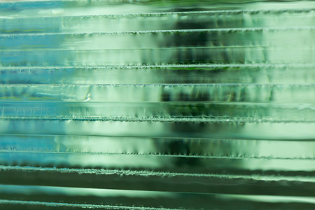 Pieces of transparent glass stacked on each other and creating reflectionsの写真素材