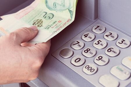 Singapore dollars withdrawn from an ATMの写真素材