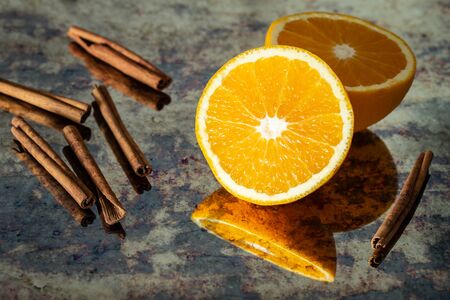 cut orange with cinnamon sticksの写真素材