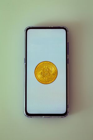 Smartphone with Bitcoin, virtual money on the screenの写真素材