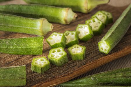 Okra. Vegeteble on a kitchen board, partly choppedの写真素材