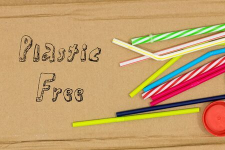 Colorful Plastic straws on a cardboard background and the inscription Plastik free The concept of a...