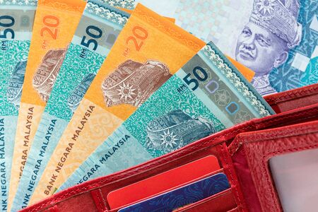 Malaysian money in the wallet on the wooden table top.