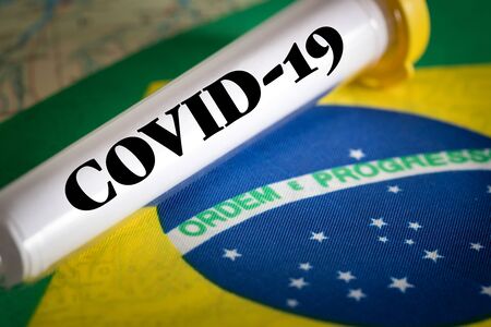 test tube with a positive Coronavirus test against the background of the Brazilian flagの写真素材