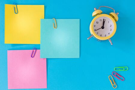 Colorful cards with space for an inscription, clock showing five minutes to twelve. office or...