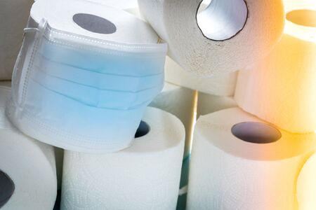 roll of toilet paper in an anti-virus mask. Symbol of purchasing goods during the Coronavirus pandemicの写真素材