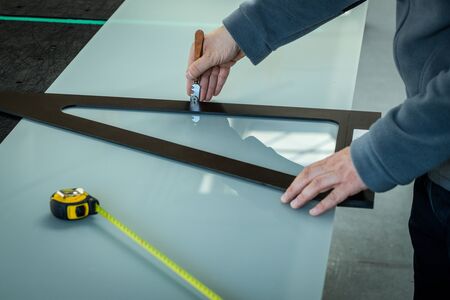 A worker cuts glass in a glass workshopの写真素材