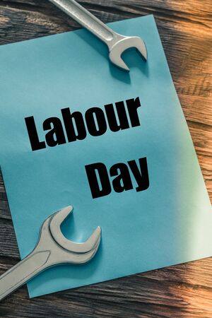 : lying on wooden boards next to assembly keys, blue card with the inscription "Labor Day"の写真素材