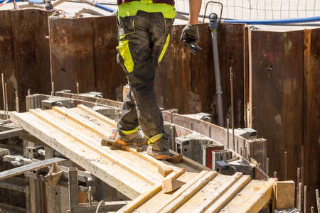 Construction worker on scaffolding on a large construction siteの写真素材