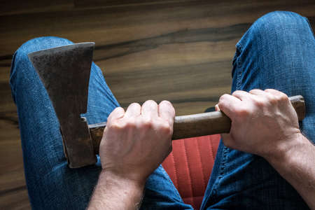 a man holding an ax in his lap. The concept of Frustration and aggressive social behavior