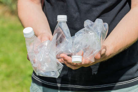 Man holding crushed plastic bottles in his hands, Concept, Eco friendly lifestyle, Zero Wasteの写真素材