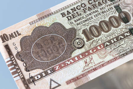 Paraguayan banknote of ten thousand guaranies. Lying on the glass and reflected in it