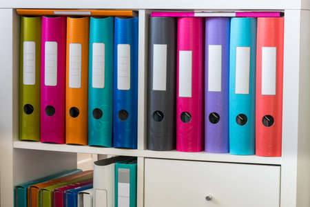 A cabinet with colorful folders and folders for office documentsの写真素材