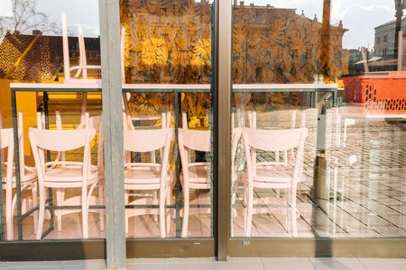 Closed restaurant, View through the glass. Inverted chairs, outside of the business conceptの写真素材